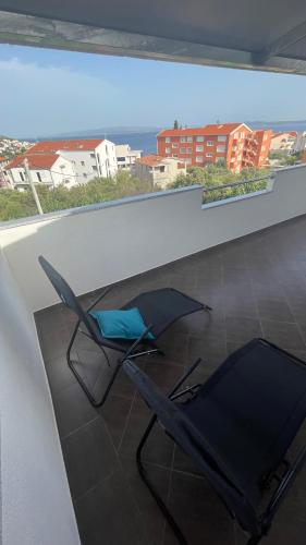 two black chairs sitting on top of a balcony at Apartments Milas in Trogir