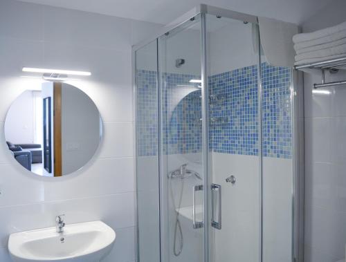 a bathroom with a glass shower and a sink at Apartamentos Rozas Vellas in Sanxenxo