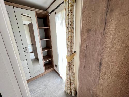 een kamer met een deur, een raam en een spiegel bij Honeysuckle Hot Tub Lodge in South Cerney