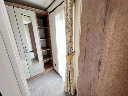 a room with a door and a window and a mirror at Honeysuckle Hot Tub Lodge in South Cerney