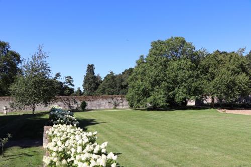 a large grass field with trees and a wall at Garden House at Woodhall Estate in Hertford