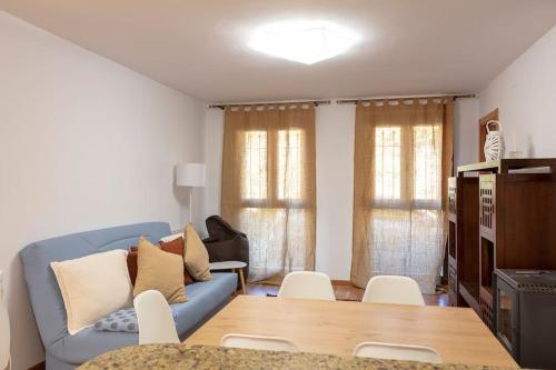 sala de estar con sofá azul y mesa en Coqueto apartamento en Valdelinares, en Valdelinares