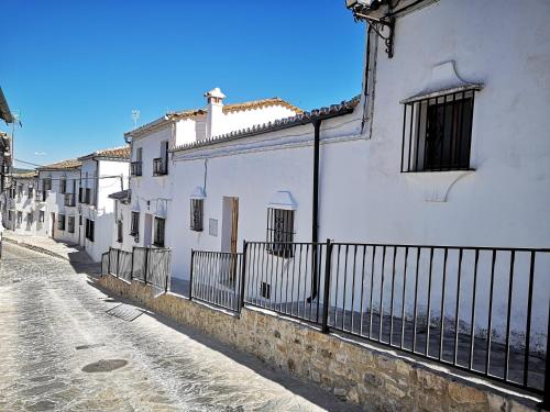 une rue avec des bâtiments blancs et une clôture dans l'établissement Mi pequeña Abril, à Grazalema