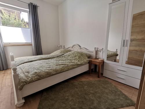 Schlafzimmer mit einem Bett, einer Kommode und einem Spiegel in der Unterkunft Sonnenufer Apartment & Moselwein II in Bernkastel-Kues