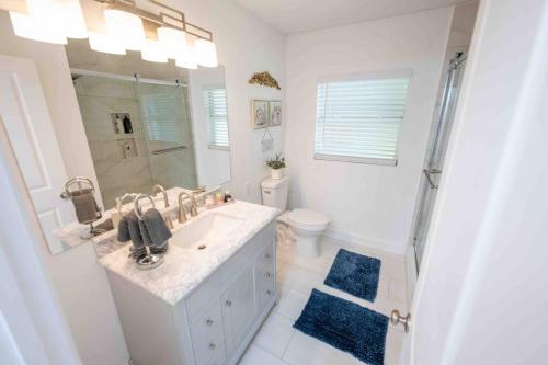 a white bathroom with a sink and a toilet at Beautiful House, Walking Distance to Stadium in Tampa