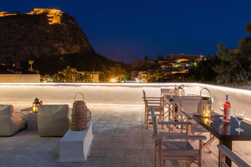 a patio with tables and chairs and a beach at night at Eudokia Pension in Nafplio