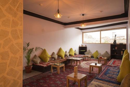 a living room with couches and tables at LeHostel in Leh