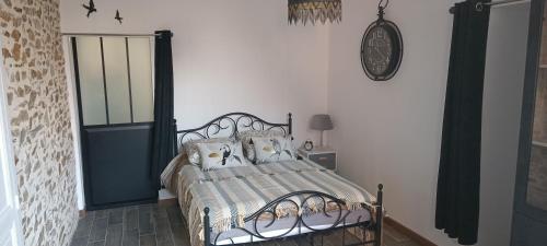 een slaapkamer met een bed en een klok aan de muur bij Gîte atypique vue panoramique in Montrevault