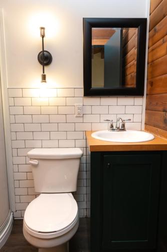 a bathroom with a white toilet and a sink at Miette Mountain Cabins in Jasper