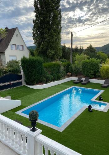 une piscine dans la cour d'une maison dans l'établissement LA VILLA Hôtel-Restaurant, à Saverne