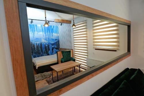 a mirror in a room with a bed and a table at Apartman KUTAK Jahorina in Jahorina