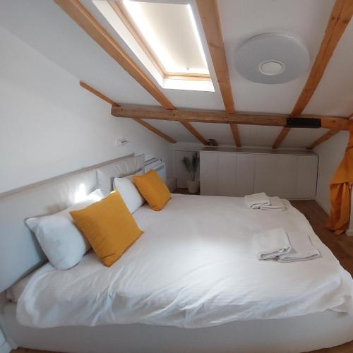 a bedroom with a white bed with yellow pillows at Villa Passage in Ohrid