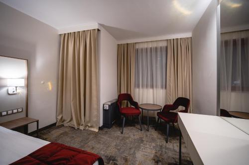 a hotel room with a bed and a table and chairs at Saint George Hotel & Medical Spa in Pomorie