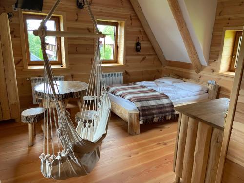 ein Schlafzimmer mit einer Hängematte in einem Blockhaus in der Unterkunft Ku Sośnie 2 in Rzepiska