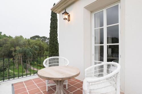 a wooden table and two chairs on a porch at Villa Bokeh Relais & Châteaux in Antigua Guatemala