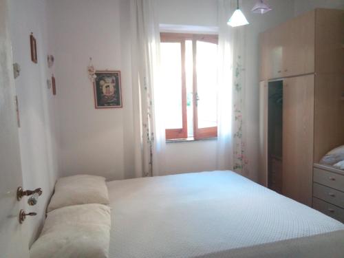 ピラーイノにあるAppartamento Aironeのベッドルーム1室(窓、白いベッド1台付)