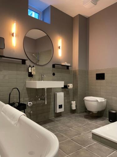 ein Badezimmer mit einer Badewanne, einem Waschbecken und einem WC in der Unterkunft Fisher´s Loft Studio in Lübeck