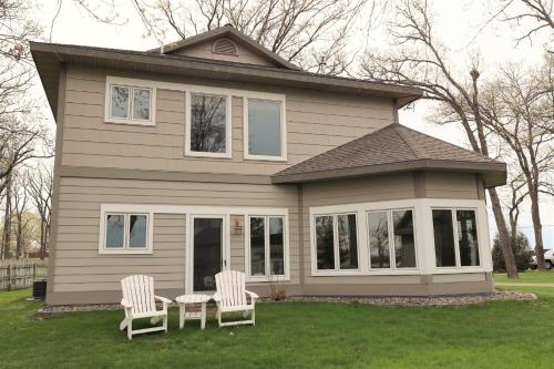 two chairs and a table in front of a house at Bay Colony 775 in Nisswa