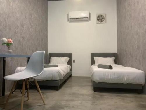 um quarto com 2 camas, uma secretária e uma cadeira em Newly Renovated (Trial Price Now) Bukit Mertajam em Bukit Mertajam