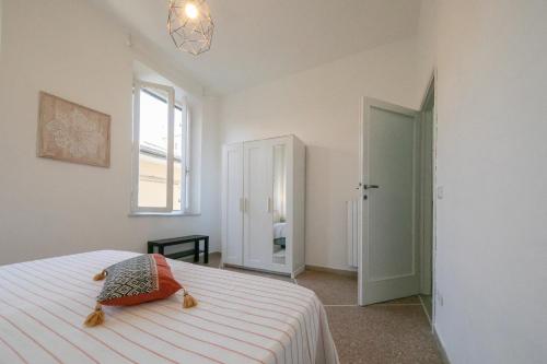 um quarto branco com uma cama e uma janela em Rooms in Chiassetto em Pisa