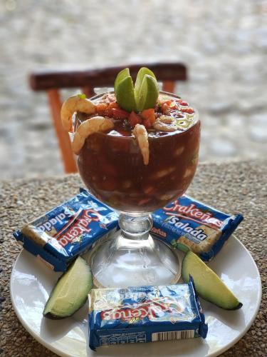 a bowl of food on a plate with crackers and dip at Hotel y Restaurante La Cabaña el Viajero in Castillo de San Felipe