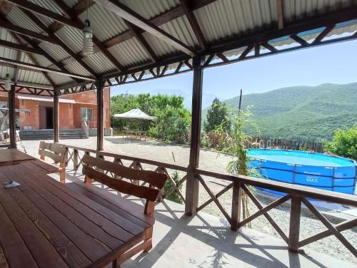 une terrasse couverte en bois avec un banc et une piscine dans l'établissement Green Garden, à Ijevan