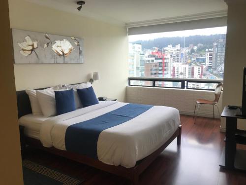 a bedroom with a bed with a view of a city at BlueZone Apartments in Quito