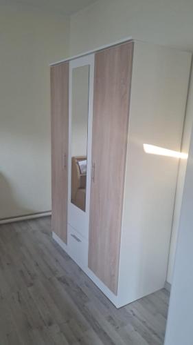 an empty room with two wooden cabinets and a refrigerator at Ferienwohnung Smillenzweg mit Garten in Lohme