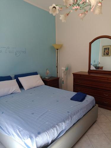 Schlafzimmer mit einem Bett, einer Kommode und einem Spiegel in der Unterkunft Casa centro Piombino in Piombino