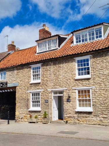 an old stone house with a red roof at Bluebird Cottage in Pickering