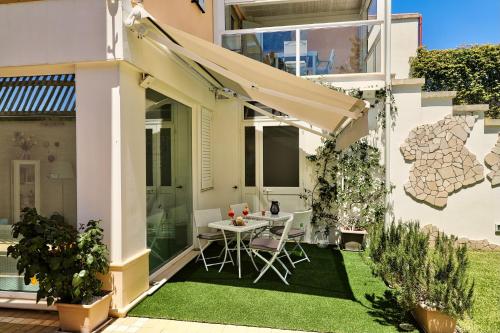 a small garden with a table and chairs under an awning at B&B SANGIORGIO Green living in Melpignano