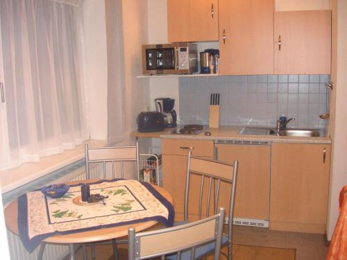 a kitchen with a table and chairs and a kitchen with a sink at Ferienwohnung Pali in Sankt Johann in Tirol