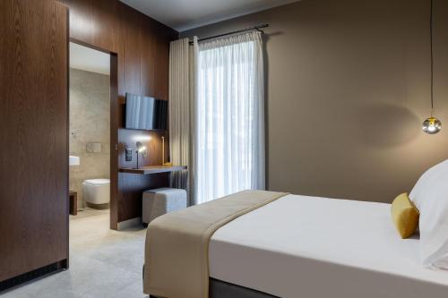 a hotel room with a bed and a bathroom at ASKLIPIOS LUXURY ROOMS in Nafpaktos