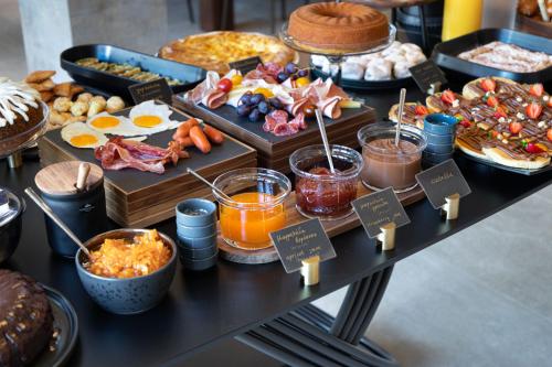 a table with a buffet of breakfast foods and desserts at ASKLIPIOS LUXURY ROOMS in Nafpaktos