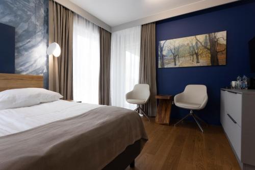 a hotel room with a bed and two chairs at Four Winds in Krynica Morska