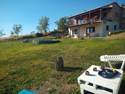 a house in a field with a table in the yard at MELENIOS HOUSES in Samothráki