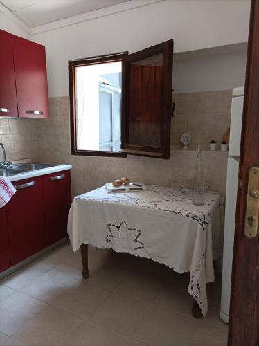a kitchen with a table with a white table cloth on it at Appartamento Oliver Villasimius in Villasimius