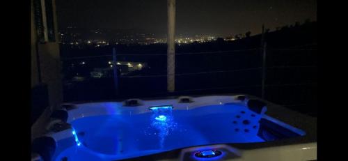 a blue tub with a view of a city at night at Casa dello Yoga Suite e Private Spa in Colonnella