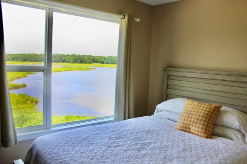 a bedroom with a bed and a large window at Surry Seafood Company in Surry