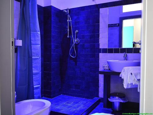 a blue tiled bathroom with a toilet and a sink at Affittacamere Tiburstation in Rome