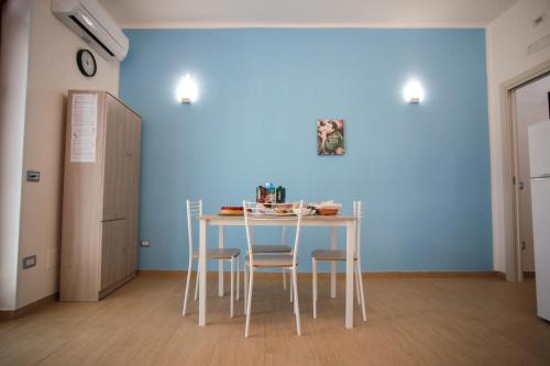 a table and chairs in a room with a blue wall at DON VINCENZO APARTMENT in Gragnano