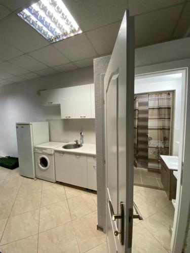 a kitchen with a sink and a washing machine at Apartman Marija in Ulcinj