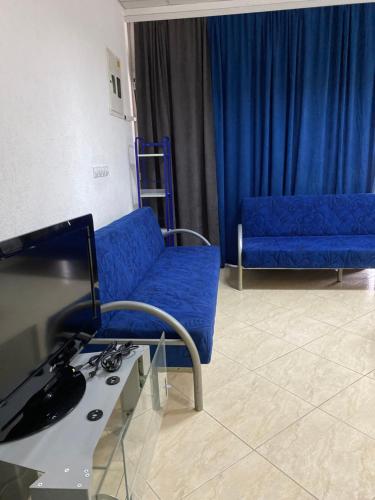 a living room with a blue couch and a tv at Apartman Marija in Ulcinj