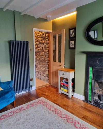 a living room with a fireplace and a blue couch at Bluebird Cottage in Pickering