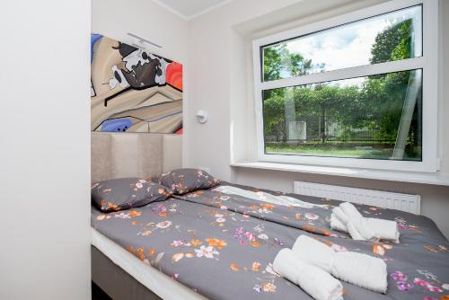 małą sypialnię z łóżkiem z oknem w obiekcie Apartament w sercu Gdyni w mieście Gdynia