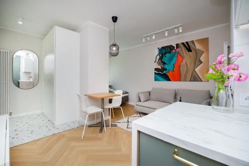 Apartament w sercu Gdyni في غدينيا: مطبخ وغرفة معيشة مع أريكة وطاولة