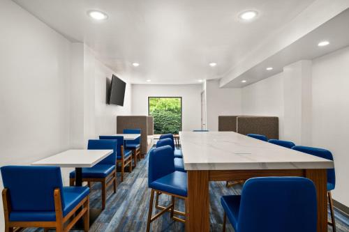 a conference room with tables and blue chairs at La Quinta Inn by Wyndham Columbus Dublin in Dublin