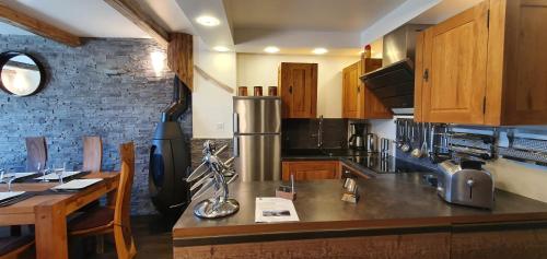a kitchen with wooden cabinets and a counter top at RESIDENCE LE PACHA Courchevel 1850 in Courchevel