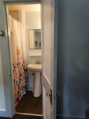 a white bathroom with a sink and a mirror at Serenity Motel in Shaftsbury