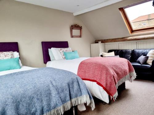 En eller flere senge i et værelse på Bluebird Cottage